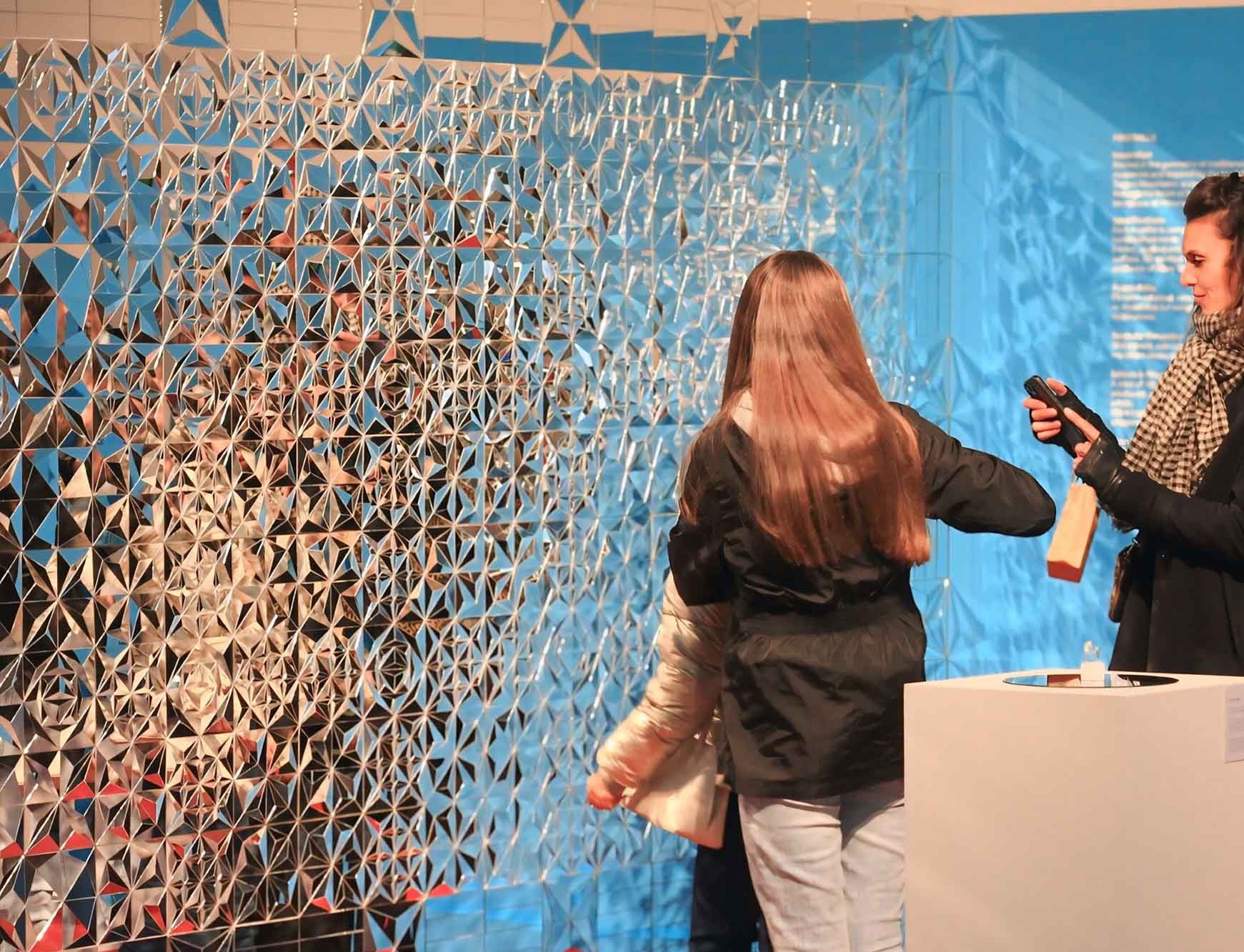 Visitors reflected across the fragmented geometric surface of Rose Garden (Golestan), an Iranian mirrorwork installation by mirroRE at Dutch Design Week 2025